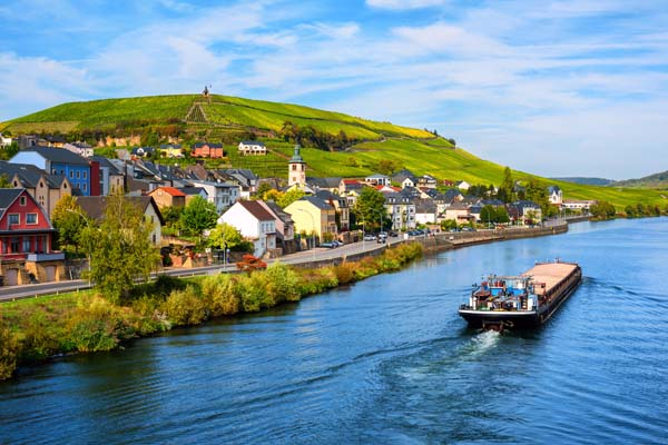 Moselle River by Wormeldange, Luxembourg country, with vineyard hills and a cargo barge ship.